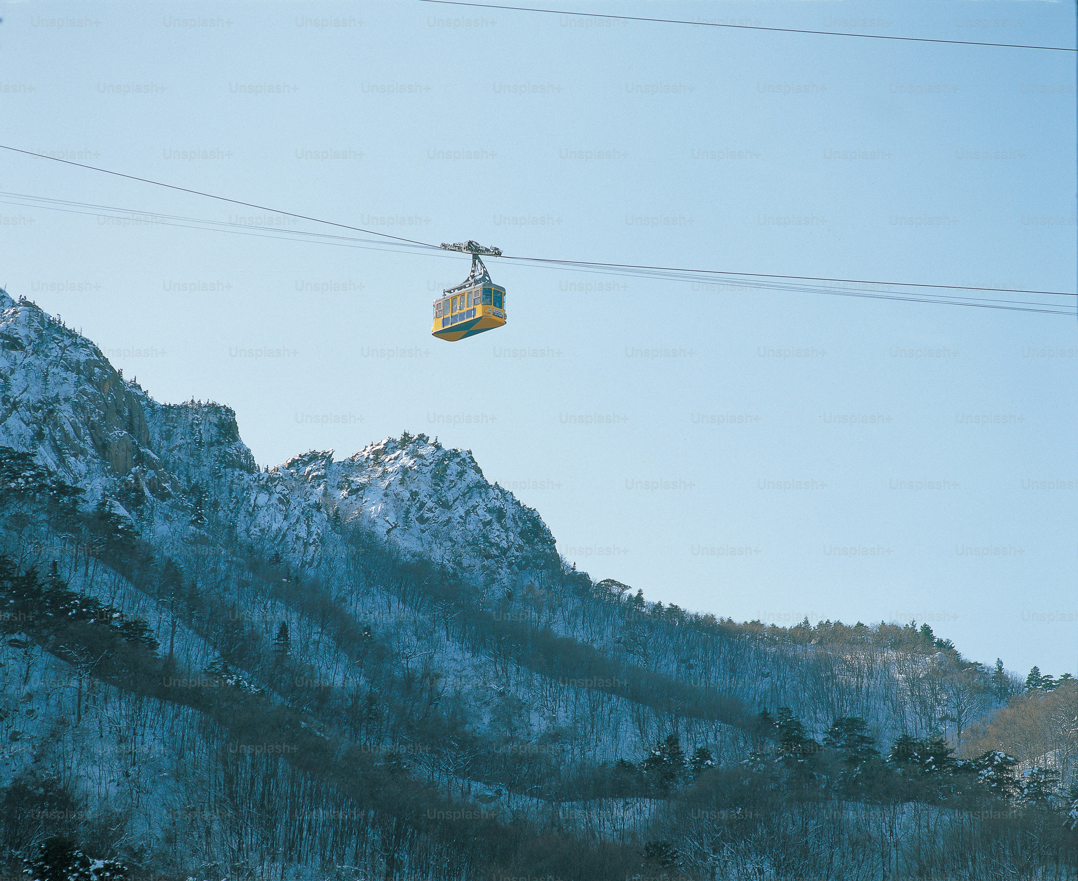 a ski lift going up a snowy mountain